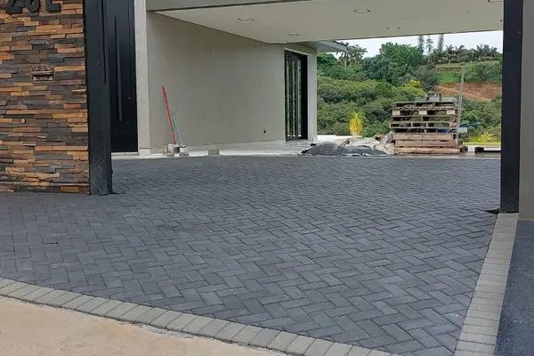 Piso intertravado cinza escuro — entrada residencial — 2026