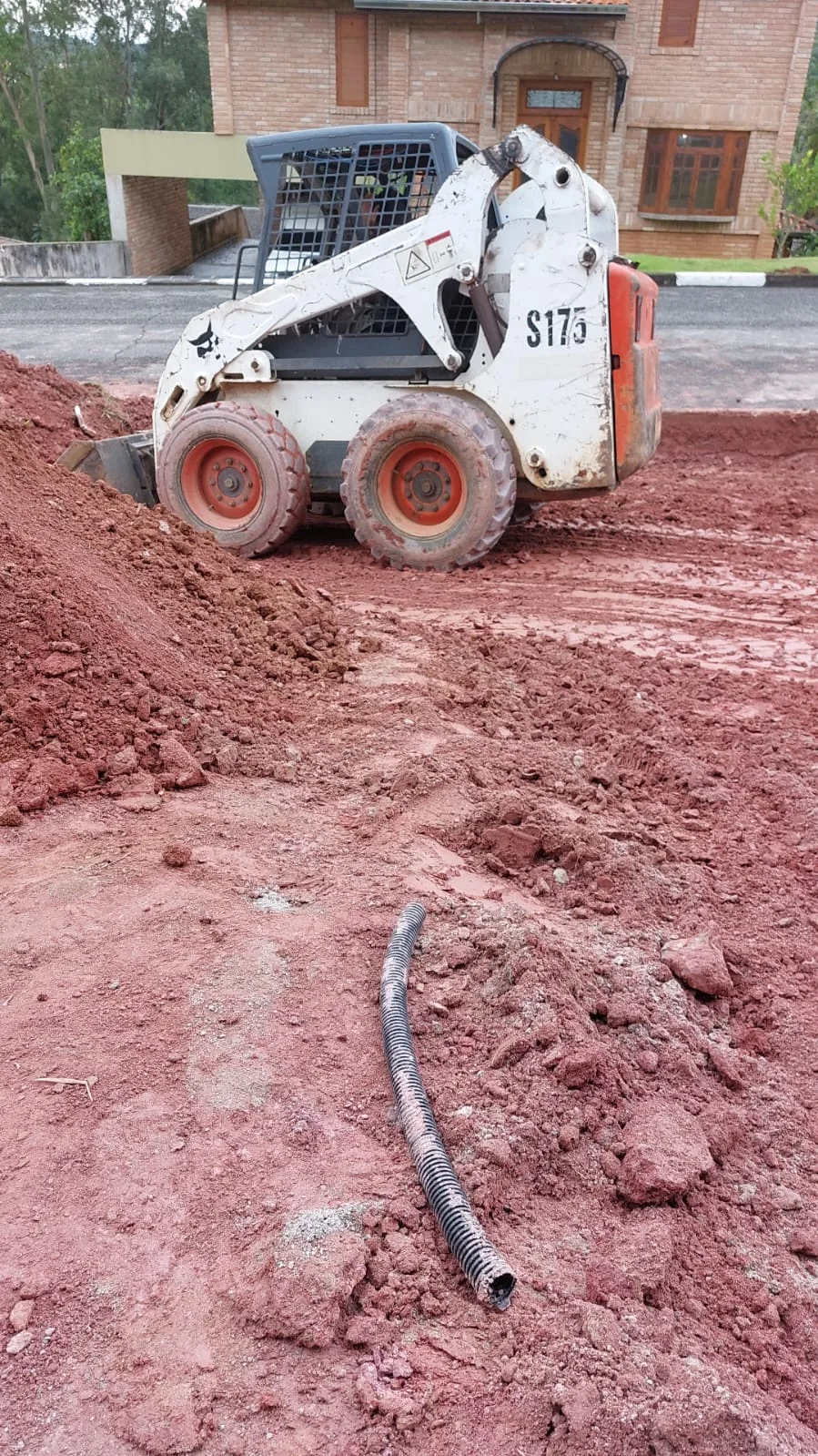 Bobcat preparando base de solo — M&M Pisos